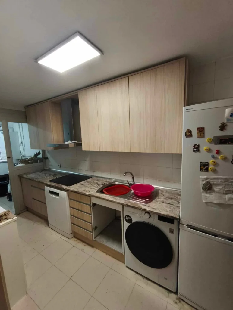 Cocina blanca y madera con lavadora y nevera americana