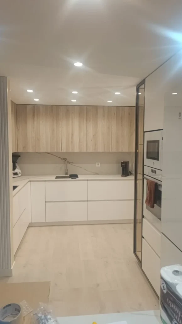 Cocina en tonos blanco y madera clara con nevera integrada