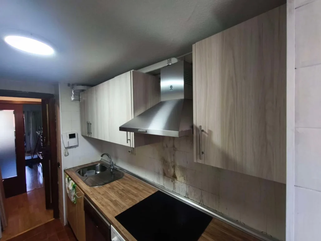 Cocina con encimera de madera y campana de acero inoxidable