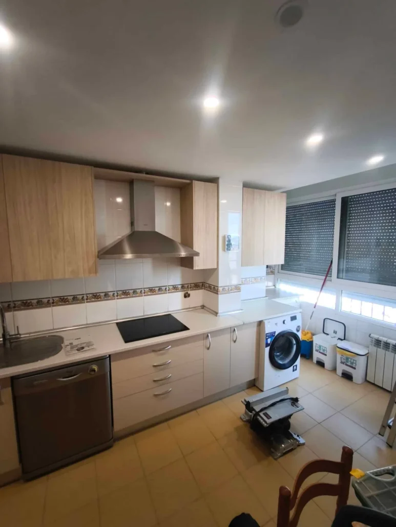 Cocina en madera y blanco con lavadora y encimera de piedra