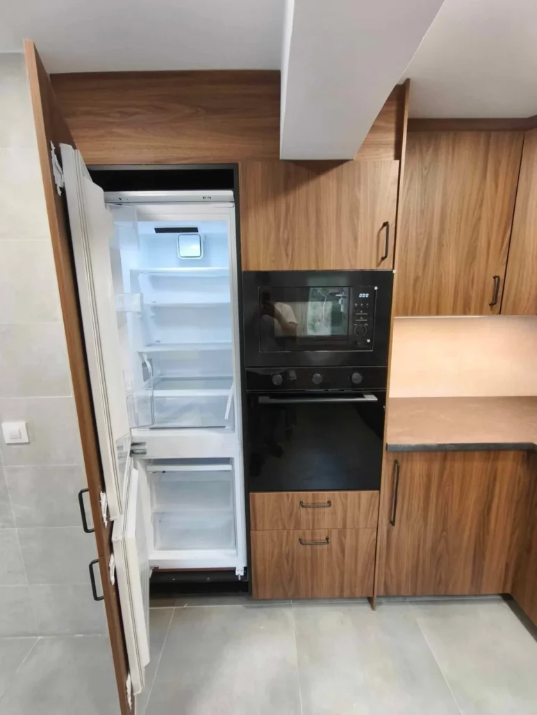 Cocina de nogal con nevera integrada y hornos empotrados