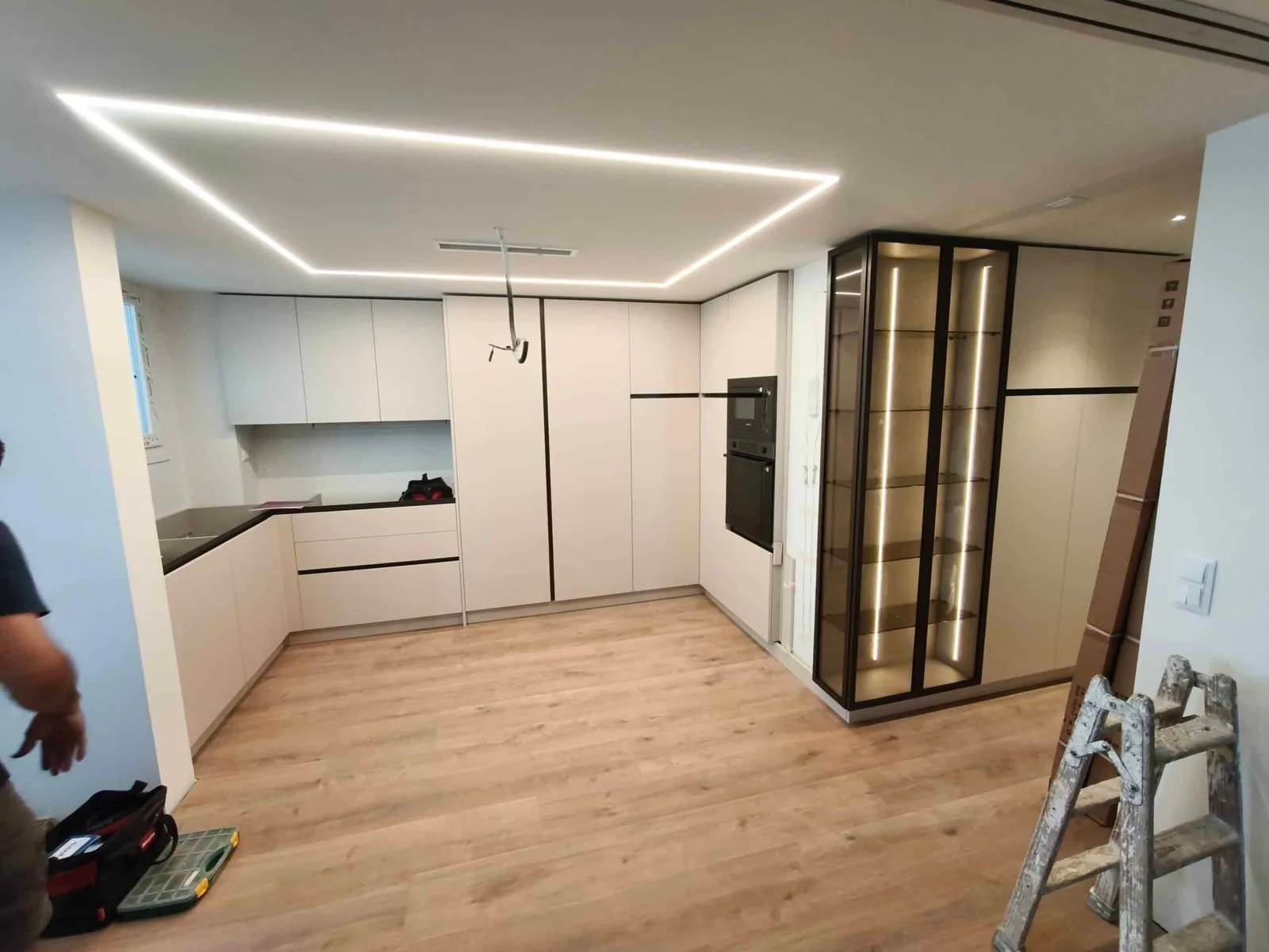 Cocina blanca en L con línea de iluminación LED en el techo en Madrid