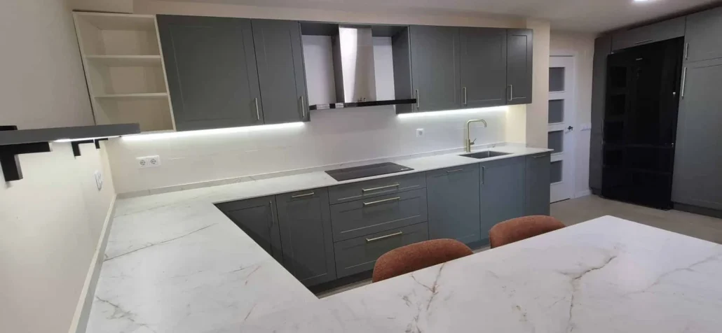 Cocina gris con barra de cuarzo y campana extractora