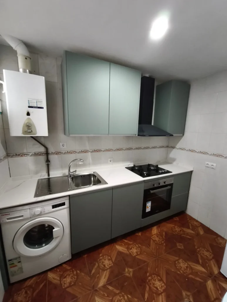 Cocina gris y verde con lavadora y suelo cerámico