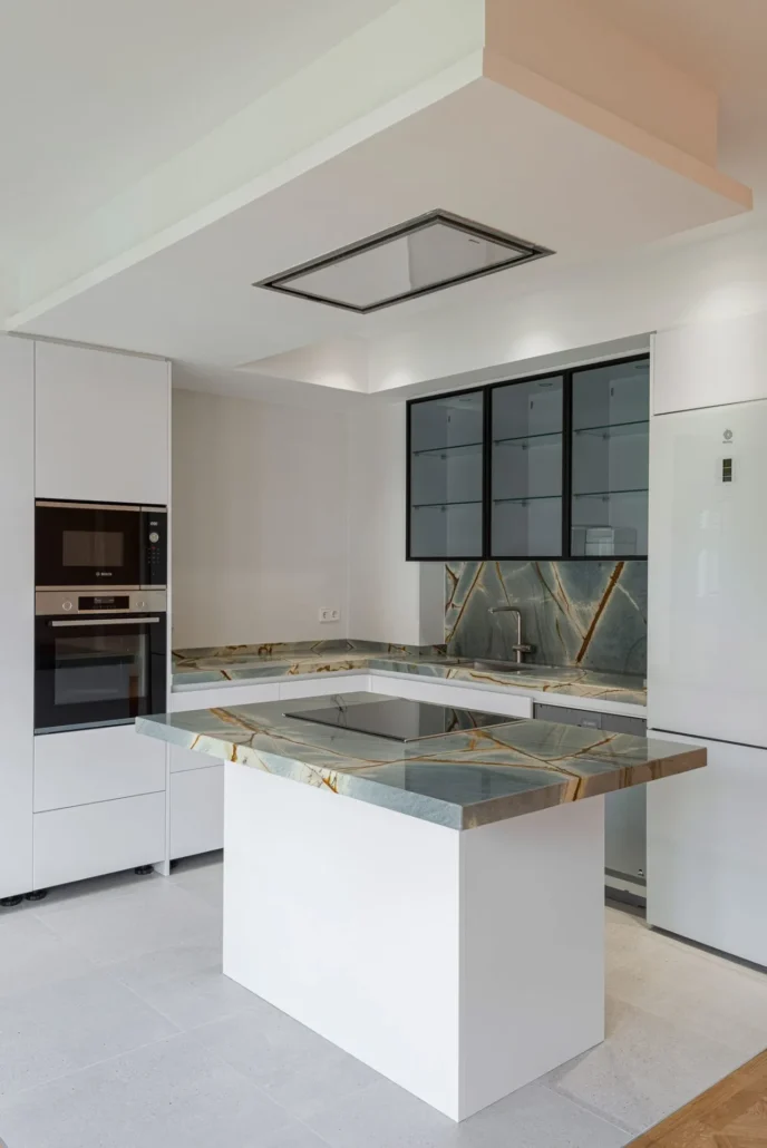 Isla de cocina blanca con placa de inducción y columna de horno